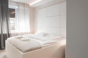 a white bedroom with a bed with white walls at B&B Fontana in Zagreb