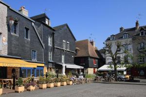 a town street with tables and chairs and buildings at LE ROMANTICA - Les Suites Romantiques Honfleur in Honfleur
