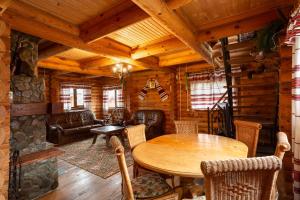 a living room with a table and chairs in a cabin at Gostynnyi Dvir Burkut in Verkhovyna