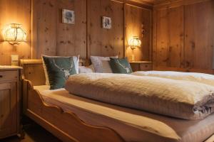 a bedroom with a large bed with wooden walls at Gasthaus Kreuz in Schruns-Tschagguns +11 photos