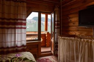 a bedroom with a window with a view of a balcony at Gostynnyi Dvir Burkut in Verkhovyna