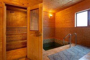 a bathroom with a shower in a wooden room at Gostynnyi Dvir Burkut in Verkhovyna +53 photos