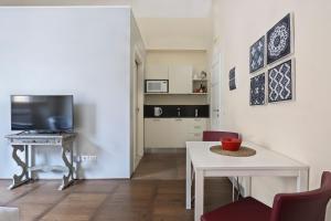 a living room with a table and a television at Apt. Fiordaliso - Pauline Suites, Palazzo Borghese in Florence