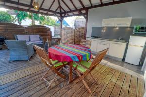 un tavolo e sedie su una terrazza con cucina di Bungalow proche plage a Sainte-Luce Altre 4 foto