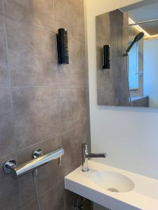 La salle de bains est pourvue d'un lavabo et d'un miroir. dans l'établissement Capsule Hotel - theLAB, à Lucerne