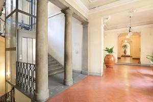 an empty hallway with columns and a staircase in a building at Apt. Perla - Pauline Suites, Palazzo Borghese in Florence