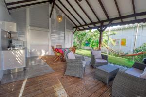 un patio con sedie e tavolo e una cucina di Bungalow proche plage a Sainte-Luce