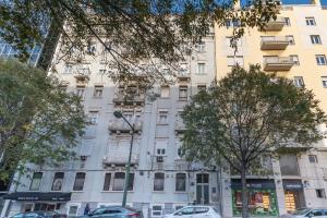 a tall white building with cars parked in front of it at Seven Dreams Suites in Lisbon