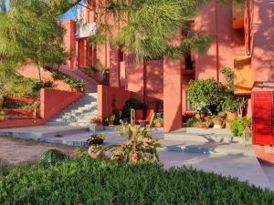 un bâtiment avec des escaliers et des plantes devant lui dans l'établissement La Muralla Roja, à Calp