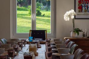 a long table in a room with chairs and a window at Amodo Lodge in Saint-Paul-en-Chablais
