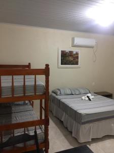 a bedroom with two bunk beds and a fan at Cantinho Dom Inácio in São Gabriel