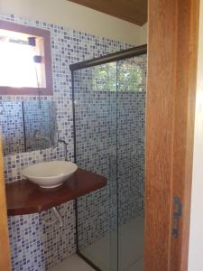 a bathroom with a sink and a glass shower at Pousada Casa Na Bolom in Barra Grande