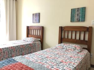 dos camas sentadas una al lado de la otra en un dormitorio en Apartamento na Praia da Prainha - Arraial do Cabo., en Arraial do Cabo