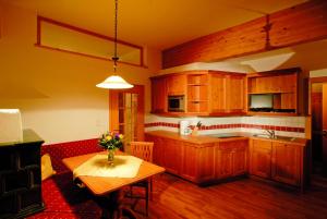 una cocina con armarios de madera y una mesa con flores. en Tonis Appartements am Achensee, en Achenkirch