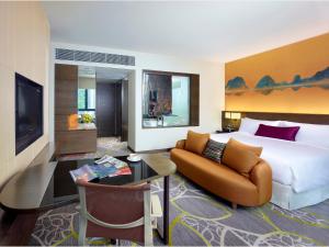 香港にあるクラウン プラザ 香港九龍東の大きなベッドとソファが備わるホテルルームです。