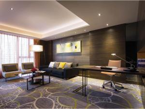 香港的住宿－香港九龍東皇冠假日酒店，客厅配有书桌和沙发。