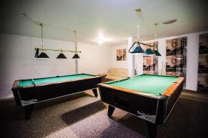 two pool tables in a room with a couch at Orion Hotel Parczew in Parczew