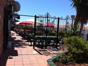 a patio with tables and chairs with umbrellas at El Capistrano Sur in Nerja