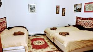 トリカラにあるTrikala Apartmentsの白い壁の客室内のベッド2台