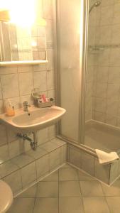 ein Bad mit einem Waschbecken und einer Dusche in der Unterkunft Hotel Haus Frieling in Dortmund