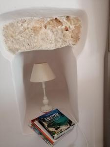 einen Tisch mit einer Lampe und ein Buch neben einem Lambert in der Unterkunft Casa Vacanze a Sud del Ciolo in Gagliano del Capo