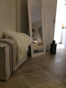 um quarto com um espelho e um sofá com um cobertor branco em Varese Playa em Mar del Plata