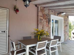 comedor con mesa de madera y sillas en Villa Foxi Murdegu, en Tertenìa