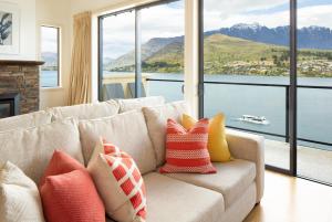 a living room with a couch with colorful pillows at Villa Del Lago in Queenstown