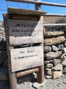 a wooden sign sitting next to a pile of rocks at Wooden House at the Mountain-private in Paránimfoi