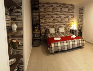 ein Schlafzimmer mit einem Bett und einer Ziegelwand in der Unterkunft Nadine Penthouse Studio in Neapel