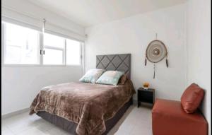 1 dormitorio con 1 cama y 1 silla en Pennsylvania WTC High End 1parking/2BR/2BA, en Ciudad de México