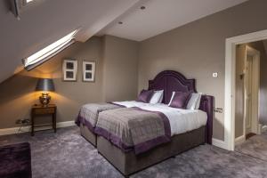 
a bedroom with a bed and a dresser at Bishop's Gate Hotel in Derry Londonderry
