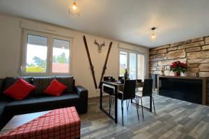 a living room with a couch and a table with chairs at Le Galtz - GÎTES MARCK in Ammerschwihr