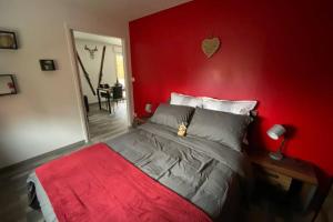 una camera rossa con un letto a parete rossa di Le Galtz - GÎTES MARCK ad Ammerschwihr