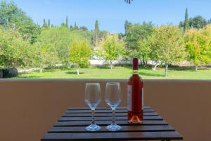 a bottle of wine and two wine glasses on a table at Marina Studios in Sidari