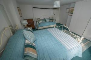 a bedroom with a large bed and a chair at Buttercup Cottage in Holt