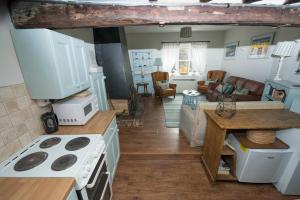 cocina y sala de estar con fogones y microondas en Buttercup Cottage en Holt