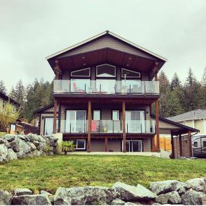 a large house with a large balcony on top at Cowichan Calling in Lake Cowichan