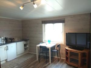 a kitchen with a table with chairs and a television at Summer haus in Syreflot