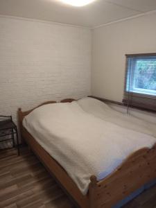 a bedroom with a wooden bed in a room with a window at Summer haus in Syreflot