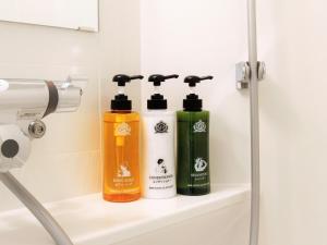 two bottles ofodorizers sit on a shelf in a bathroom at APA Hotel Kyoto Ekikita in Kyoto
