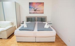 a bedroom with a large white bed and a couch at 1020 | VIE | Apartment in Vienna