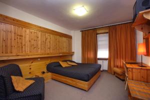 a bedroom with a bed and a chair in it at Hotel Splendid in Sauze dʼOulx +52 photos