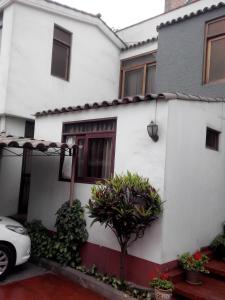 una casa blanca con un coche aparcado delante de ella en Habitación amoblada en Surco, Lima, Peru, en Lima
