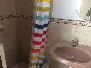 y baño con cortina de ducha y lavamanos. en Habitación amoblada en Surco, Lima, Peru, en Lima