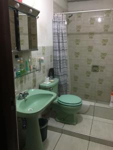 a bathroom with a green toilet and a sink at Habitación amoblada en Surco, Lima, Peru in Lima