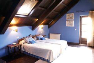 Un dormitorio con una cama grande con paredes azules. en Hostal Meson Leira Antiga, en Cedeira