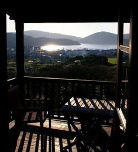 un banco en un balcón con vistas a la ciudad en Hostal Meson Leira Antiga, en Cedeira