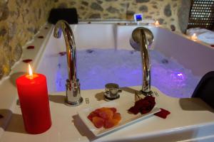 a candle sitting next to a bath tub with a sink at Casa das Fiadeiras de Nemiña in Nemiña