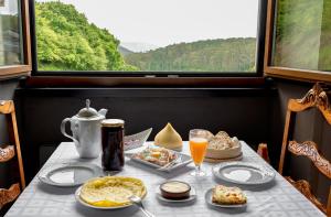 a table with food and drinks and a window at Casa das Fiadeiras de Nemiña in Nemiña